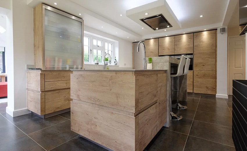 Modern kitchen with wood cabinets, island, bar stools, and large windows.