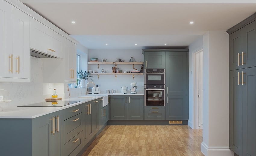 Modern kitchen with blue and white cabinets, wooden floor, open shelves, and built-in appliances.