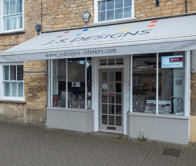 A storefront with a sign reading "JS Designs" and a website on an awning above the entrance.