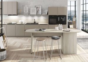 Modern kitchen with beige cabinets, an island, and two stools, in a bright room with large windows.