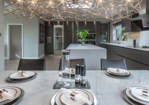 Modern kitchen and dining area with set table, elegant lighting, and minimalist decor.