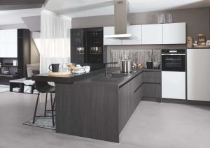 Modern kitchen with dark cabinets, white upper cabinets, and a center island with seating.