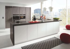 Modern kitchen with a large island, sleek cabinets, and bright natural light from large windows.