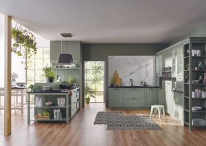 Modern kitchen with green cabinets, open shelves, island, and wood flooring.