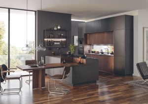 Modern kitchen and dining area with dark cabinets, wood accents, and large windows.