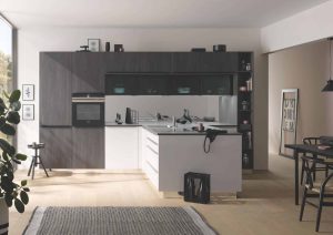 Modern kitchen with dark cabinets, white island, and dining area in a bright, open space.
