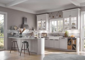 Modern kitchen with white cabinets, a large window, and a breakfast bar with two stools.