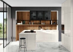 Modern kitchen with white cabinets, wood accents, an island, and a black stool on a marble floor.