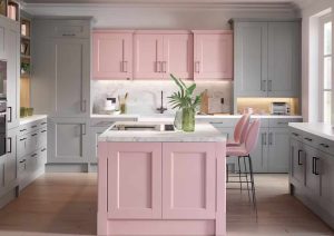 Modern kitchen with pink and gray cabinets, a center island, and a plant on the countertop.