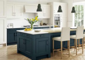 Modern kitchen with navy island, white cabinets, bar stools, and large windows letting in natural light.