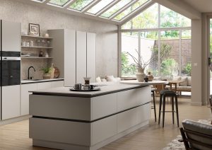 Modern kitchen with a large island, skylights, and floor-to-ceiling windows overlooking a garden.