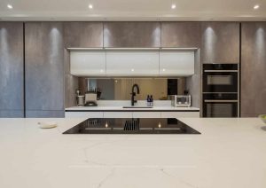 Modern kitchen with a sleek island, built-in appliances, and minimalist grey cabinets.